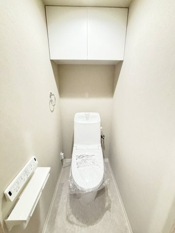 ダイアパレス新石切フォレストタウン292のトイレ|温水洗浄便座と手洗い、2連のペーパーホルダー、タオルリング、収納付きのトイレ