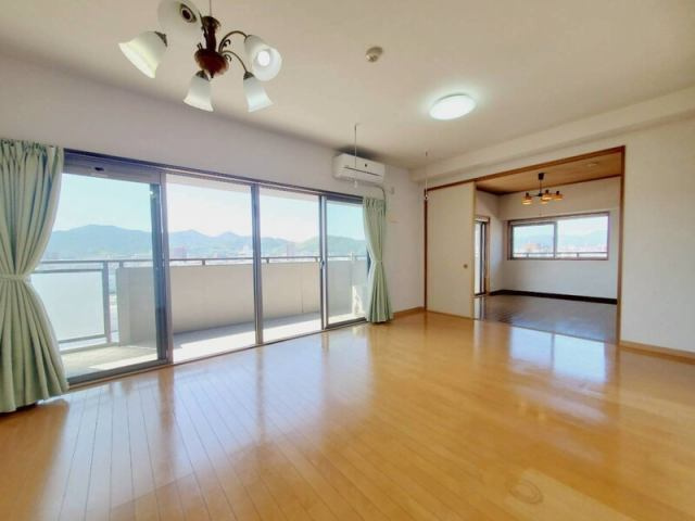 高知市新田町　サーパス新田の居間・リビング|「日差しがたっぷり入る南向きリビング。和室とつながる設計で家族の会話も自然と弾みます