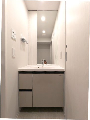 LEFOND PROGRES上野御徒町の洗面所|トイレと独立した洗面室、ハンドシャワー付独立洗面台、タオルフックにスマホストレージ付です、洗面室の洗濯機置場上段収納の下にハンガー収納パイプ付、排水口のお手入れしやすく中央手前に配置し、足高の防水パン