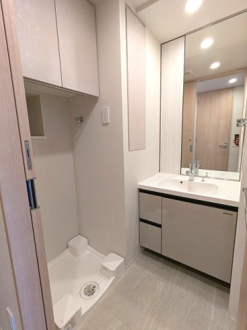 LEFOND PROGRES上野御徒町の洗面所|トイレと独立した洗面室、ハンドシャワー付独立洗面台、タオルフックにスマホストレージ付です、洗濯機置場上段収納の下にハンガー収納パイプ付、排水口のお手入れしやすい様に中央手前に配置し、足高の防水パンです