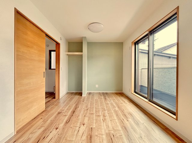 高知市竹島町　中古住宅の洋室|大きな窓から光が広がる、風通しの良い明るい洋室。落ち着いたアクセントクロスが魅力。