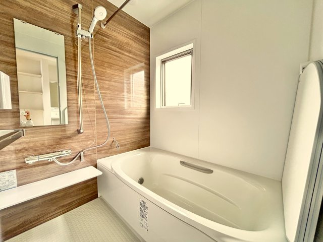 高知市竹島町　中古住宅の浴室|落ち着いた木目デザイン×広めの浴槽。明るい窓付きで換気も◎。清潔感あふれる浴室で快適なバスタイムを。
