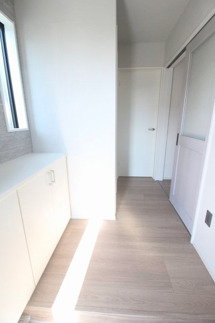 小山市城西　2期　2号棟の玄関|収納付きで、鍵や小物をすっきり整理できます！アクセントクロスがおしゃれな空間を演出し、ご家族や来客を気持ちよく迎えられます。