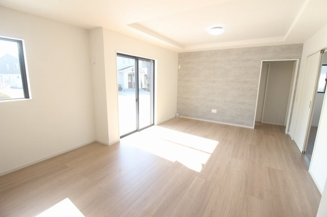 小山市城西　2期　2号棟の居間・リビング|南側の掃き出し窓から心地よい陽射しが差し込む明るい空間！アクセントクロスがお部屋の雰囲気を引き締め、おしゃれなリビングを演出しています。