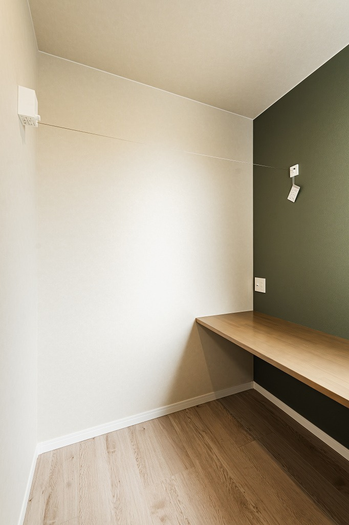 乙訓郡大山崎町小字尻江のその他|オリーブグリーンのアクセントクロスが印象的なドライルームは物干しワイヤーを設置しております。