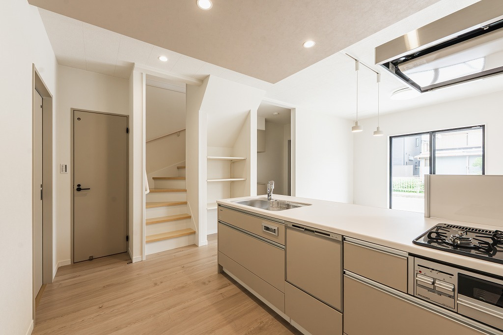 乙訓郡大山崎町小字尻江のキッチン|グレージュカラーのキッチンにグレージュの折り下げ天井を施すことによって統一性が演出されるとともに空間にメリハリも出してくれます。