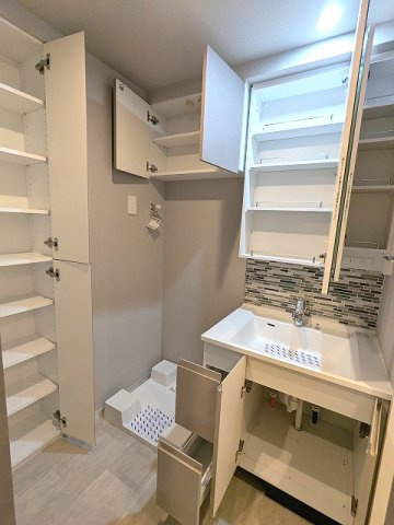 SEASON FLATS新御徒町EASTの洗面所|トイレと独立した洗面室に洗濯機置場、2面鏡・ハンドシャワー付洗面台、洗面台の下にヘルスメーターストックあり、洗濯機置場は排水口のお手入れしやすい様に手前に配置した防水パンです