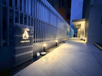 建物サインとアルミルーバーで導かれるアプローチ