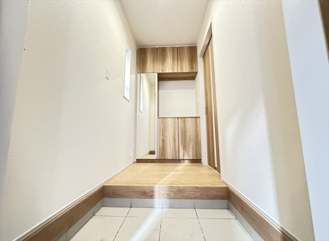 【玄関】 | 志木市柏町2丁目　新築一戸建住宅　全2棟　(志木本店) | 窓から優しい光が入る明るい玄関。鏡面付きの玄関収納はお出かけ前の身だしなみチェックにも便利です。