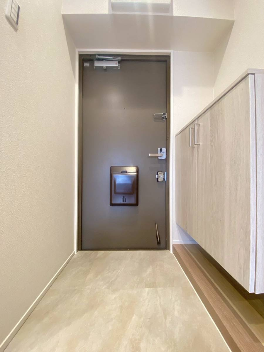 【価格改定】西京極ガーデンハイツの玄関|玄関土間からの段差がなく、スムーズに入室できます。フロートタイプのシューズボックスはホワイト系で圧迫感が少なく、収納力は確保されています。