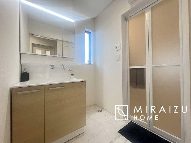 【洗面所】 | 洗濯機置き場と脱衣スペースもしっかりと確保されている洗面室、洗面コーナーは、窓から陽も差し明るく開放的な造りです。家事導線も良いので洗濯物やお湯はりもストレスフリーに毎日家事を楽しめそうです。
