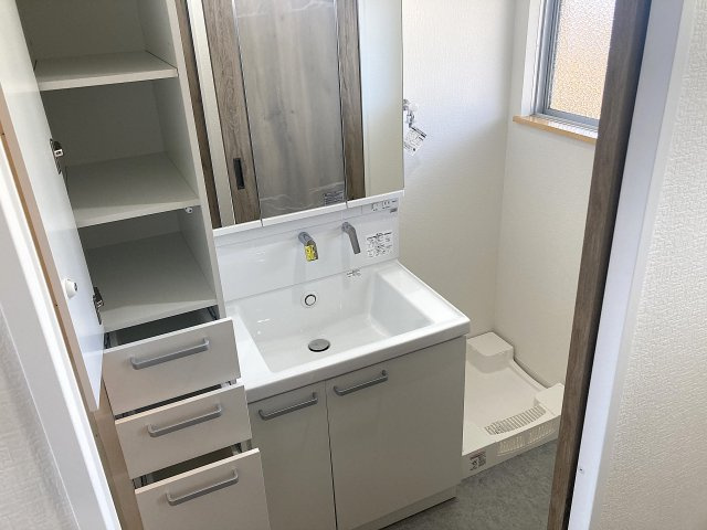 ラムール下三条の洗面所|3面鏡の洗面台に、便利な収納棚付きの広々洗面脱衣所