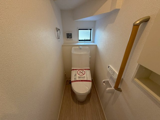 高知市高須3期2棟 2号棟のトイレ|小窓からの光がやさしく差し込む明るいトイレ。手すり付きで安心感のある、使いやすい空間です