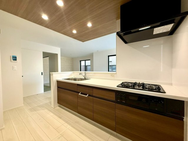 高知市高須3期2棟 2号棟のキッチン|落ち着いた木目とホワイトのコントラストが美しい。明るく清潔感のあるキッチンで、毎日の家事も気持ちよく