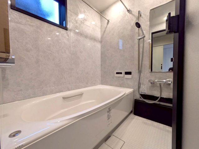 高知市鴨部　新築一戸建て（西棟の浴室|ゆったりとしたバスルーム。石目調のパネルが上質な空間を演出します。