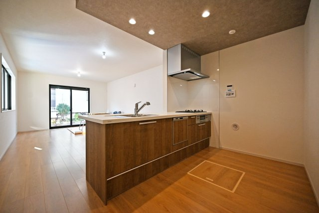 テラシエ浜田町2丁目新築一戸建て│4LDK+駐車1台可のキッチン|1階LDKをキッチン越しに撮影した現地内観写真です。 広くて使いやすいキッチンは折り下げ天井を採用しており、 オシャレな空間に仕上がりました。