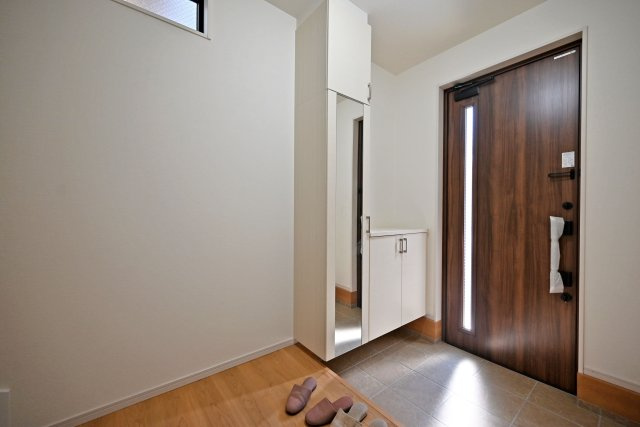 テラシエ浜田町2丁目新築一戸建て│4LDK+駐車1台可の玄関|1階玄関をホール側から撮影した内観写真です。 シンプルな玄関扉にシューズボックス、小窓を配置したオーソドックスな玄関です。