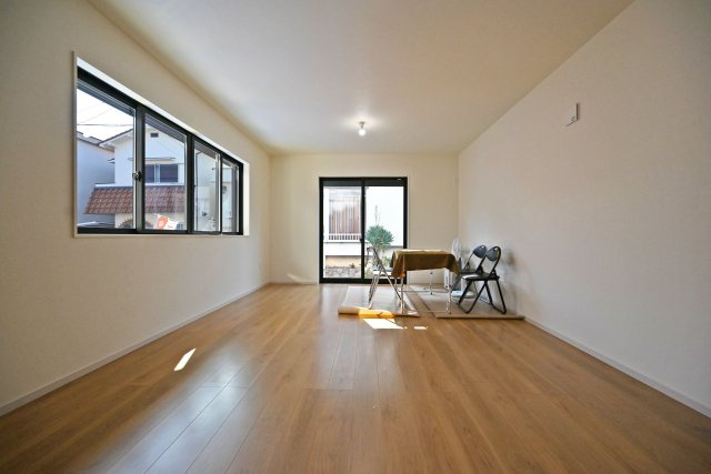 テラシエ浜田町2丁目新築一戸建て│4LDK+駐車1台可の居間・リビング|1階LDKをキッチン側から正面に撮影した内観写真です。奥行きがある縦長リビングなので、収納や家具の配置、インテリアコーディネートがしやすいです。