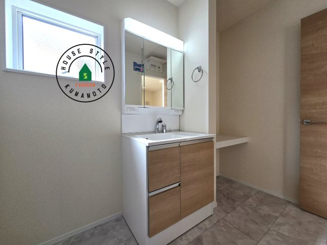 熊本市北区植木町広住第1₋2棟(1号棟)の独立洗面台|毎日使うものだから清潔な空間を保ちたい水回り。洗面にはそんな願いを解消させてくれる収納アイデアが満載です。三面鏡の裏側にはキャビネットが現れ小物から背の高い物まで収納できます。