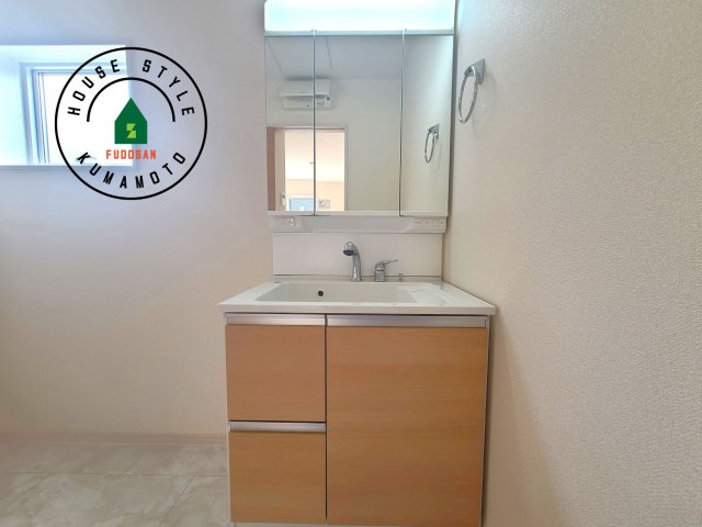 熊本市北区植木町広住第1₋2棟(2号棟)の内観：施工例|毎日使うものだから清潔な空間を保ちたい水回り。洗面にはそんな願いを解消させてくれる収納アイデアが満載です。三面鏡の裏側にはキャビネットが現れ小物から背の高い物まで収納できます。