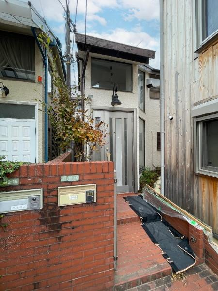 駒沢一丁目　古家付土地のその他|特徴的な玄関扉が目を引く外観です。レンガの塀と階段が印象的で都市型住宅の雰囲気を感じられます。前面には郵便受けも設置されています。