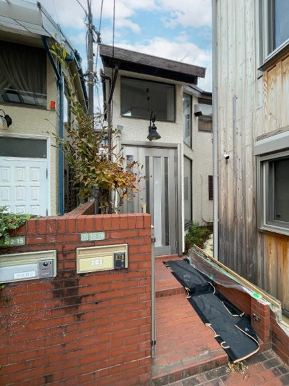 【その他】 | 駒沢一丁目　古家付土地 | 特徴的な玄関扉が目を引く外観です。レンガの塀と階段が印象的で都市型住宅の雰囲気を感じられます。前面には郵便受けも設置されています。