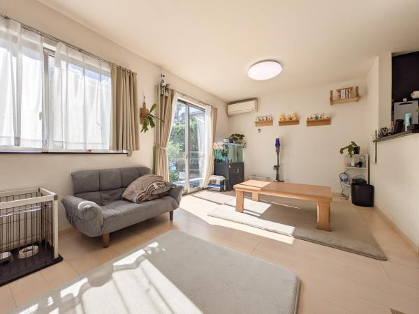 坂ノ市中央　中古の居間・リビング|南向きの大きな窓からしっかりと陽が差し込むリビングです。シンプルな内装で幅広いインテリアに合わせやすい空間です。ナチュラルな色合いが落ち着いた雰囲気を演出しています。