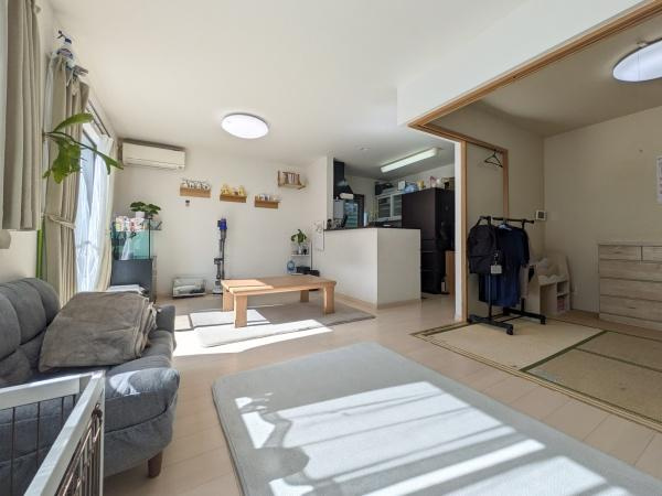坂ノ市中央　中古の居間・リビング|リビングにはたっぷりの日差しが差し込み全体的に明るい印象です。室内はすっきりとしたレイアウトで空間を効果的に活用できます。隣接する和室スペースとのつながりもあり開放感が感じられます。