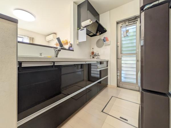 坂ノ市中央　中古のキッチン|スタイリッシュな印象のキッチンです。収納スペースが豊富で整理しやすい設計となっています。明るい室内で作業がしやすく清潔感も感じられます。勝手口があり換気やゴミ出しにも便利です。