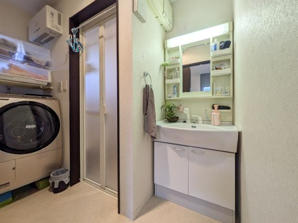 坂ノ市中央　中古の独立洗面台|洗面台には収納棚が備え付けられており日用品の整理に便利です。明るい照明が設置され毎日の身支度も快適です。洗面台のデザインがシンプルで清潔感があります。