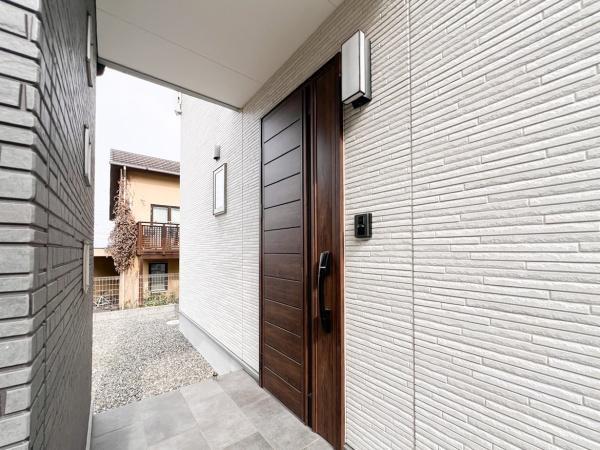 津守　中古の玄関|庇がしっかりとあるポーチで雨の日でも安心。落ち着いた色合いの玄関ドアが印象的です。外壁とのコントラストが美しくスタイリッシュな雰囲気が魅力的。
