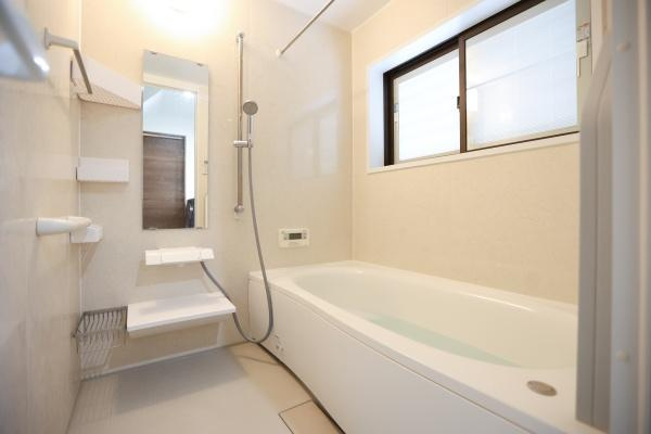 津守　中古の浴室|清潔感のあるバスルームはゆとりのある広さで快適に使えます。窓付きで換気もしやすく明るい空間を実現。手すりや収納棚も設置されており使いやすさにも配慮されています。