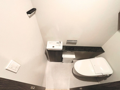 【トイレ】 | クレヴィア三軒茶屋 | タンクレストイレを採用し、空間を広く利用できます。シックな黒のカウンターと手洗いボウルを備え、清潔感とデザイン性を両立したホテルライクな空間です。