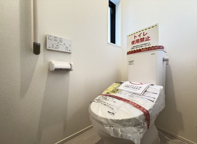 【トイレ】 | 富士見市水谷東2丁目　新築一戸建住宅　全1棟　(志木本店) | 1階トイレ／家族を感染症から守る温水洗浄便座を完備。妊婦さんやお子様のトイレトレーニングにも便利な手摺付です。

