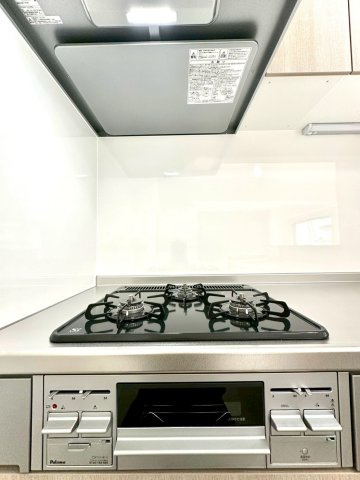 ビッグヴァン二俣川ホームズのキッチン|3口ガスコンロとグリルを備えた使い勝手の良いキッチン。光沢のある天板が上質さを引き立てます。