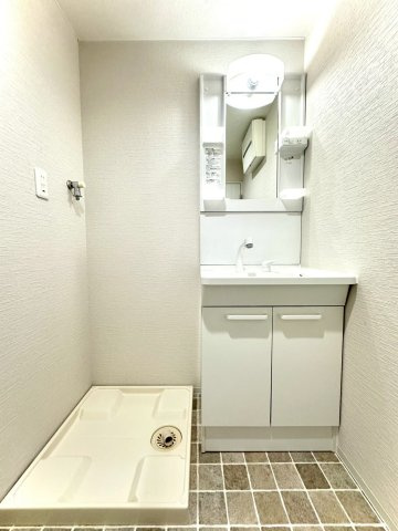 ビッグヴァン二俣川ホームズの独立洗面台|石目調フロアが上質な印象を与える洗面室。洗濯機置場を備え、家事動線にも優れた空間設計です。