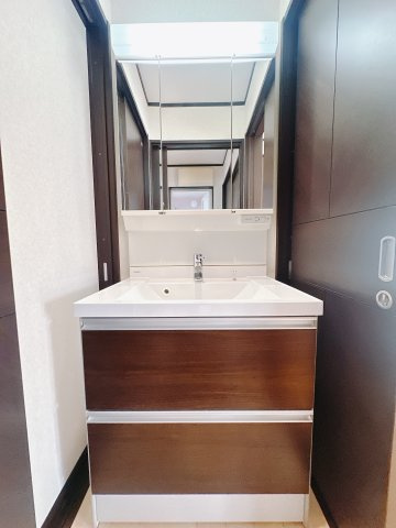 【中古戸建】伊勢崎市境百々の独立洗面台|■洗面室｜三面鏡の洗面台は鏡の裏が収納ポケットになっているので、ヘアケア用品や歯ブラシなどでごちゃつきがちな洗面台周りがスッキリ片付きます。　