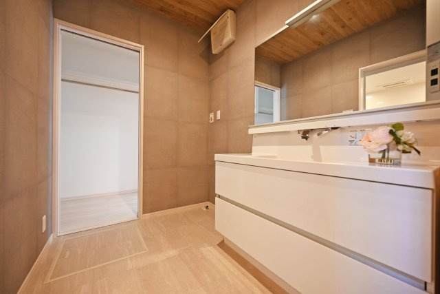 宝塚市山手台東5丁目中古戸建│3LDK+並列駐車2台可の独立洗面台|1階洗面室に入ってすぐの内観写真です。朝の支度が気持ちいいワイドタイプの洗面台です。
収納豊富で、タオルなどの日用品やスキンケア用品などもたくさんしまえてすっきりとした空間を保つことができます。