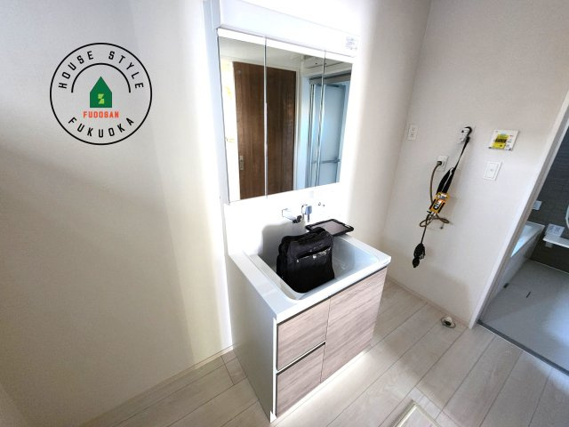 福岡市西区小戸3丁目第1-3棟（3号棟）　の独立洗面台|毎日使うものだから清潔な空間を保ちたい水回り。洗面にはそんな願いを解消させてくれる収納アイデアが満載です。三面鏡の裏側にはキャビネットが現れ小物から背の高い物まで収納できます。