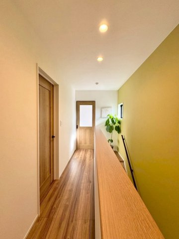 守山市大門町　中古戸建ての内装|2F廊下部分。グリーン系のアクセントクロスと、フローリングの木目がマッチしてとてもお洒落な空間です。