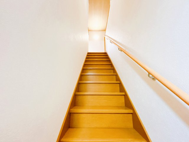 【その他共用部分】 | 紋別郡遠軽町西町３丁目３－２６０　中古売家 | 【リフォーム後】1階廊下から見た階段写真です。手すりも付いており上り下りも安心ですね。階段スペースの壁紙クロスも全て貼替致しました。