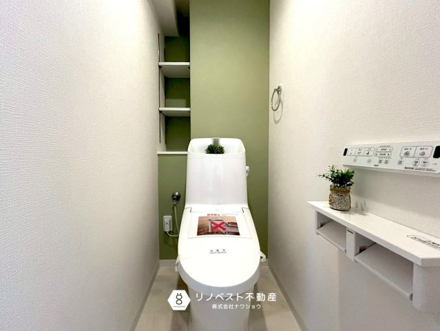 ファミール緑橋のトイレ|グリーン基調の壁紙でオシャレ度UPですね！棚もあるのでトイレットペーパーのストックや掃除用具を収納できそうですね！