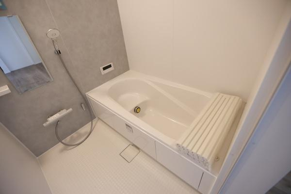 横尾東町2丁目2期1号棟の浴室|清潔感のあるバスルームです。浴槽はゆったりとした形状でリラックスしやすい仕様です。シャワーとミラーも備わっており便利にご利用いただけます。床は滑りにくい素材を使用しています。