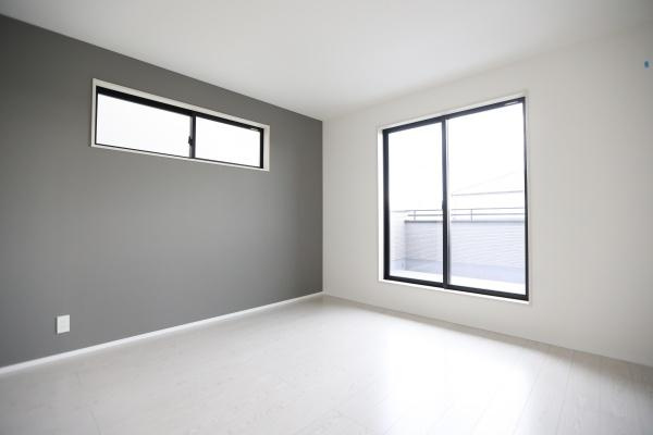 横尾東町2丁目2期2号棟の洋室|大きな窓から光が差し込む洋室です。落ち着きのあるアクセントクロスが印象的です。室内は白を基調とした明るい空間です。シンプルな内装で家具のレイアウトがしやすい洋室です。