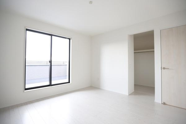 横尾東町2丁目2期2号棟の洋室|明るい日差しが差し込む洋室です。床や壁の色合いが統一されており空間がすっきりとしています。クローゼットも備わっていて収納スペースが確保されています。窓が大きく開放感を感じることができます。