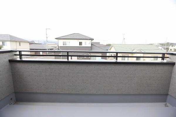 横尾東町2丁目2期2号棟のバルコニー|ゆったりとしたスペースが魅力のバルコニーです。見晴らしも良く開放感を感じられます。手すり部分がスタイリッシュな印象を与えます。周囲の住宅街の景色が穏やかです。周辺環境も落ち着いています。