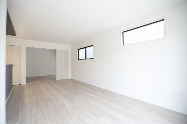 横尾東町2丁目2期2号棟の居間・リビング|リビングはシンプルな内装で明るい光が広がる空間です。スタイリッシュなフローリングが特徴です。窓からの採光により快適に過ごせます。開放的な印象のリビングです。