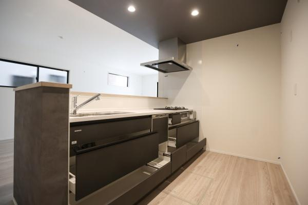 横尾東町2丁目2期2号棟のキッチン|モダンなデザインが印象的なキッチンです。ライトグレーとブラックの組み合わせが空間を引き締めています。天井や壁もシックな色合いで統一され洗練された雰囲気です。