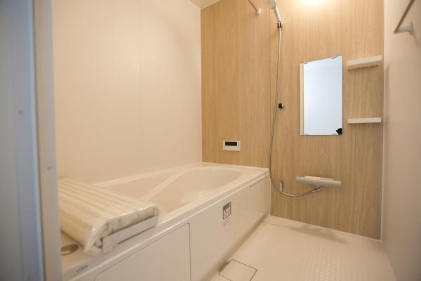 横尾東町2丁目2期3号棟の浴室|清潔感のあるバスルームで明るい色合いが特徴です。シンプルな内装で使いやすい空間です。浴槽にはフタがついており洗い場も広々としています。壁付けのミラーや棚も設置されており整理しやすい仕様です。