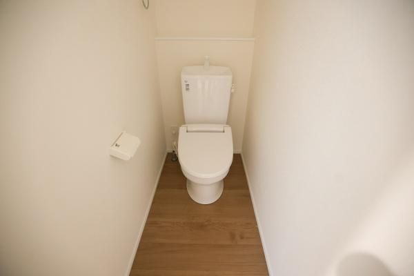 横尾東町2丁目2期3号棟のトイレ|シンプルなデザインで清潔感のあるトイレです。床材は温かみがあり落ち着いた印象を与えます。無駄のない空間設計となっています。壁際にペーパーホルダーが設置されています。